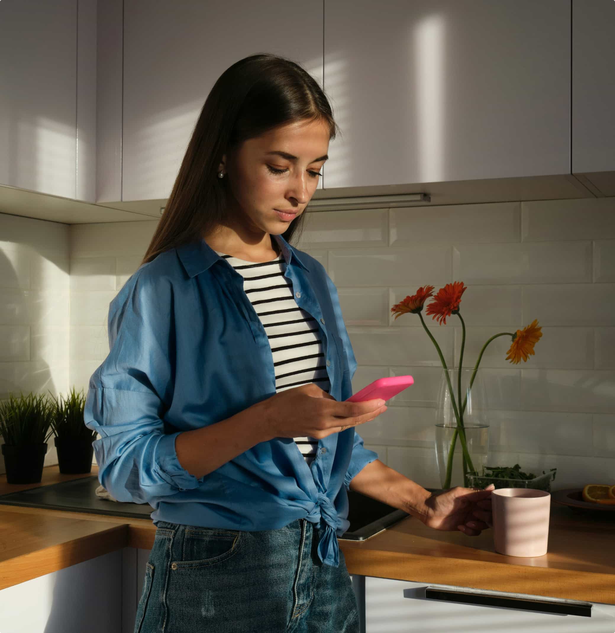 woman looking mobile phone in the kitchen